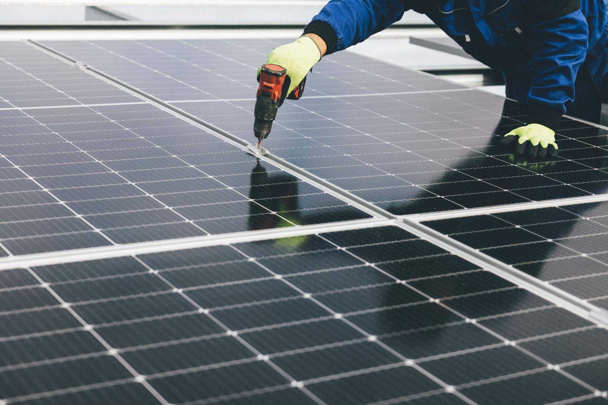 A person securing screws on a solar panel